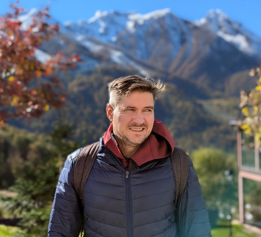 Portrait of Konstantin Selivanov in front of a mountain landscape